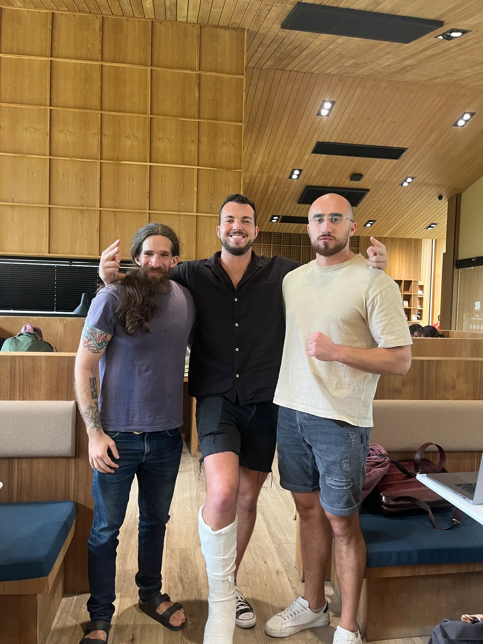 Three people posing together in a wood-paneled interior
